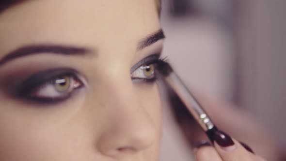 Makeup Artist Applying Eye Shadow Makeup to Model's Eye