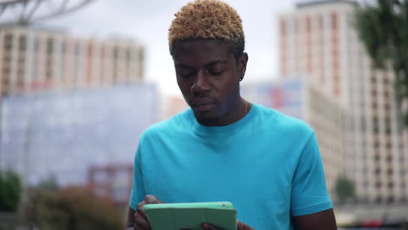 Portrait of Focused Smart African American Young Man Scrolling Tablet Touchscreen in Slow Motion