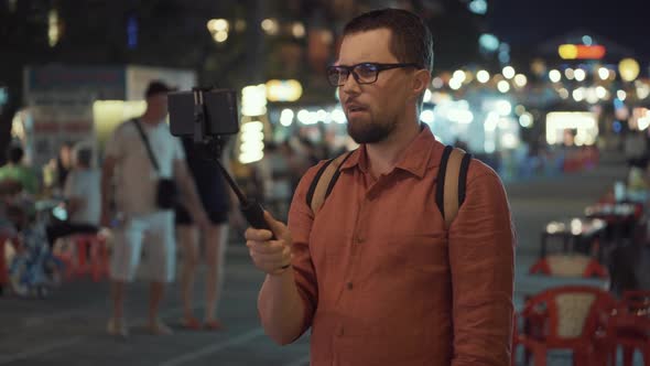 Male Traveler is Filming Himself By Smartphone on Street in Asia