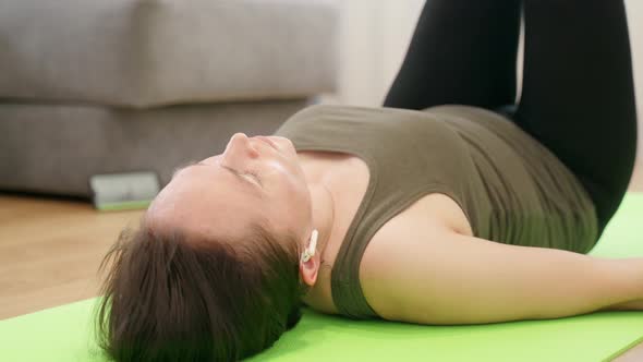 Woman Performs Fitness Exercises at Home Using an Application on a Smartphone