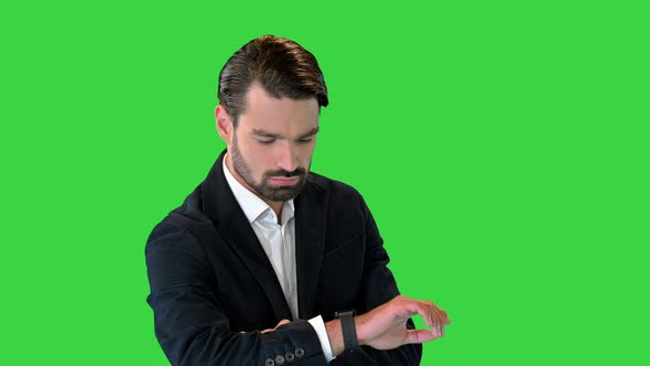 Businessman Using Digital Watch While Standing on a Green Screen Chroma Key