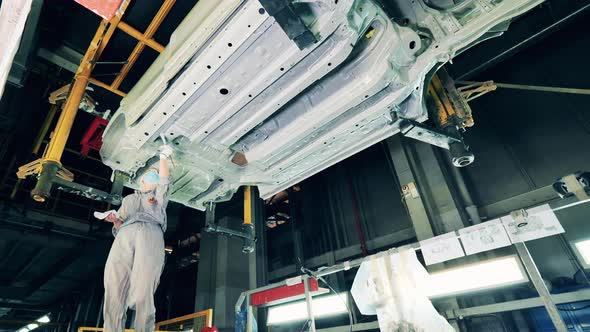 Female Worker Is Putting Zinc Paste Onto the Car Body