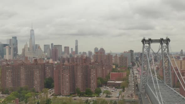 AERIAL: Flight Over Williamsburg Bridge Manhattan Side with New York City Skyline at Cloudy Day 