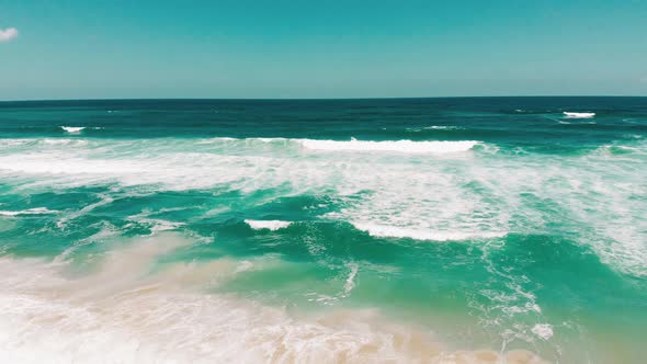 aerial droneing fast showing endless wild sea waves breaking