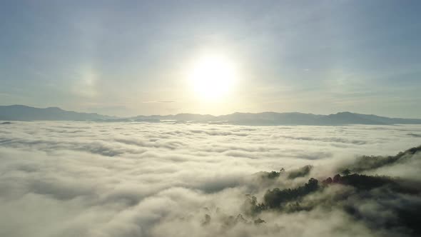 Aerial view Drone flying through the fog above mountain peak