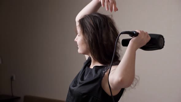 Nice and Calm Lady Enjoys Drying Hair with Modern Styler