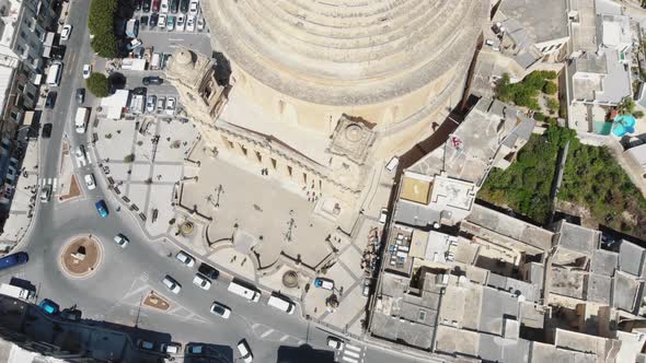 Bird's-eye view aerial 4k footage flying over the Mosta Rotunda Dome and it's surrounding city