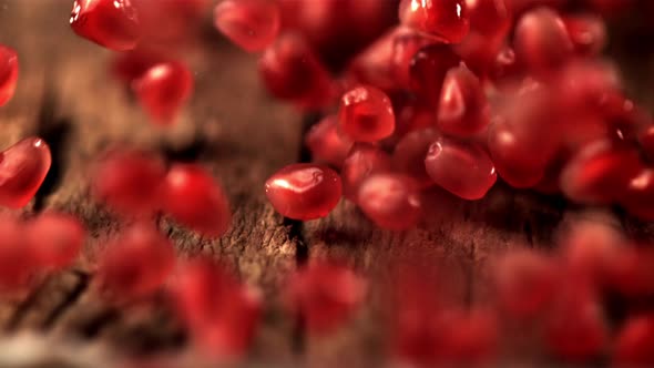 Super Slow Motion of Pomegranate Grains Roll Over the Wooden Table