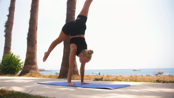 Gymnastics By the Sea  Plastic Blonde Woman Doing Gymnastic Exercises on Yoga Mat
