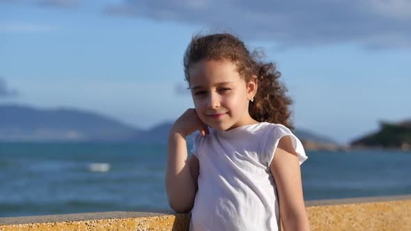 Portrait of a Happy European Child Girl Smiling Cheerful Enjoying Warm Summer Vacation at Seaside