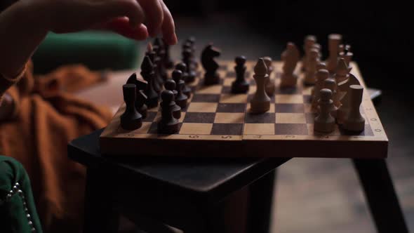 Closeup Side View of Unrecognizable Female Hands Moving Black Pawn on Chessboard During Chess Game