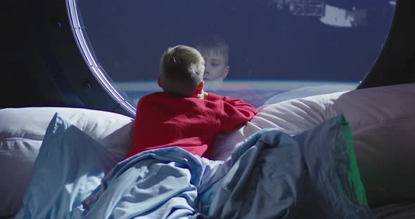 Boy Looking Out of Spaceship Window