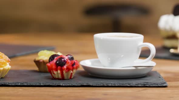 Close Up Dolly Shot of Sweet Fruit Tarts and a Cup of Coffee