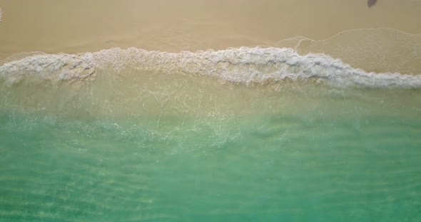 Tropical overhead abstract shot of a sunshine white sandy paradise beach and blue water background 