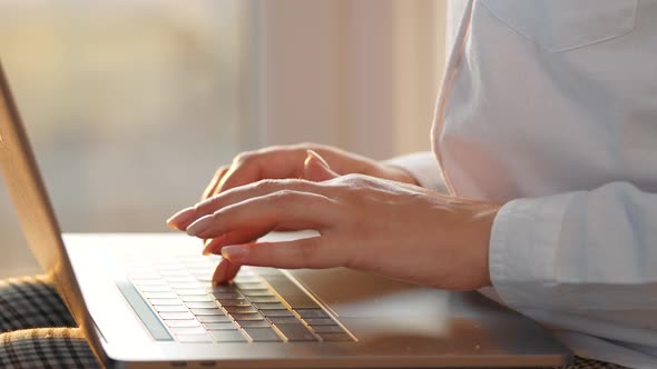 Closeup Woman Working on a Laptop Against the Sunset