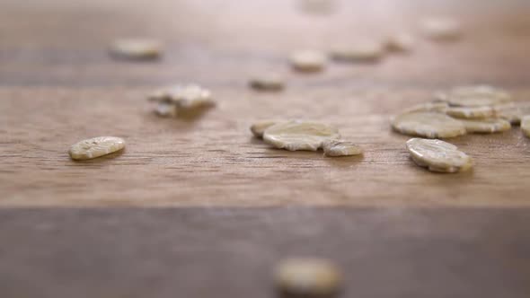Oat flakes on a wooden rustic surface. Falling dry oatmeal in slow motion