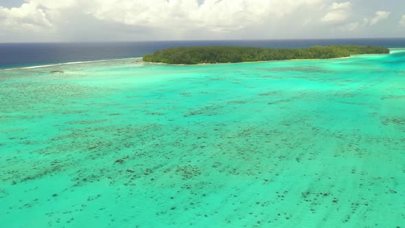 Aerial establishing shot of the gorgeous barrier reef surrounding Mo'orea island in French Polynesia