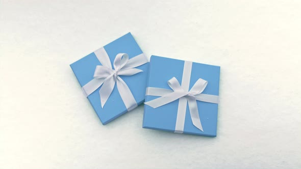 Beautiful Pastel Blue Boxes with White Satin Ribbon Simple Bows Snow Background