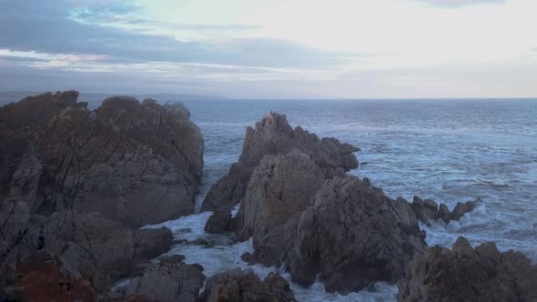 Aerial over a rocky coastline with waves breaking