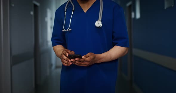 A Doctor is Talking on a Mobile Walking Along the Corridor of the Medical Center