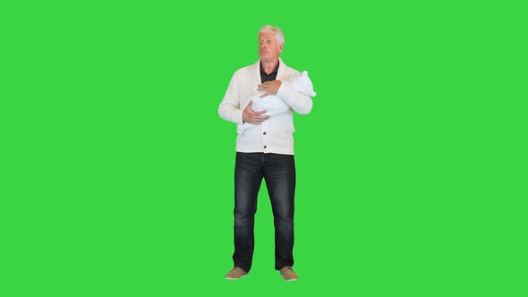 Shocked Grandfather Holding His Grandson on a Green Screen Chroma Key