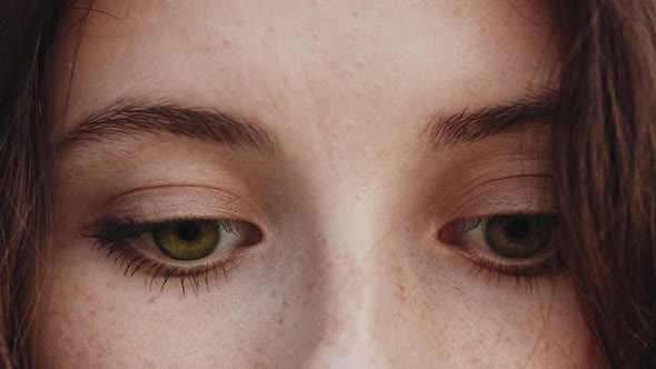 Green Eyes of Young Pretty Woman with Freckles