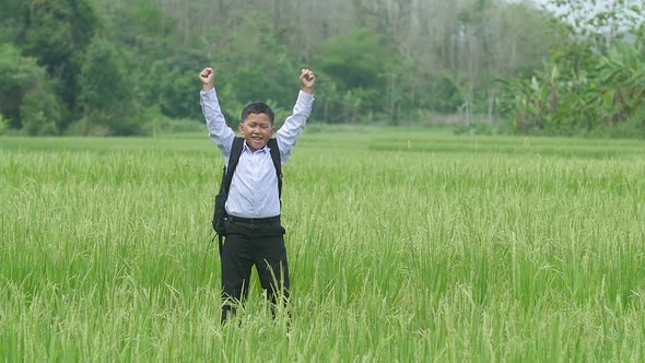 Asian Student Jumping In Rice Field