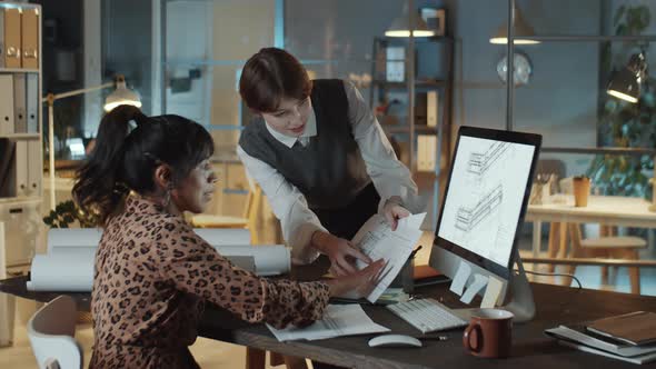 Diverse Female Colleagues Working on Architectural Plan in Night Office