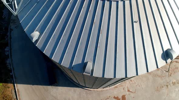 Modern granary at sunlight. Grain elevator. Large silver container for agriproducts. Close-up. View 