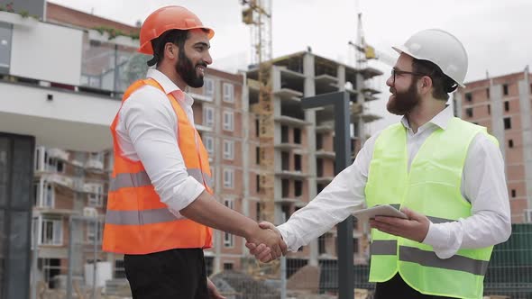 Construction Manager and Workers Shaking Hands on Construction Site. Professions, Construction