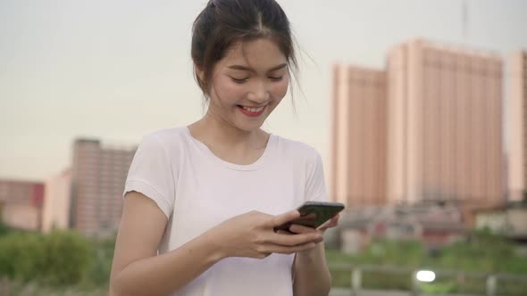 Asian tourist blogger woman using smartphone for direction and looking on location map.