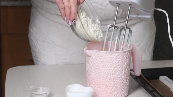 A Woman Adds Flour To A Container, Makes Dough.