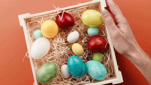 Hand with Basket of Painted Easter Eggs Comes Out