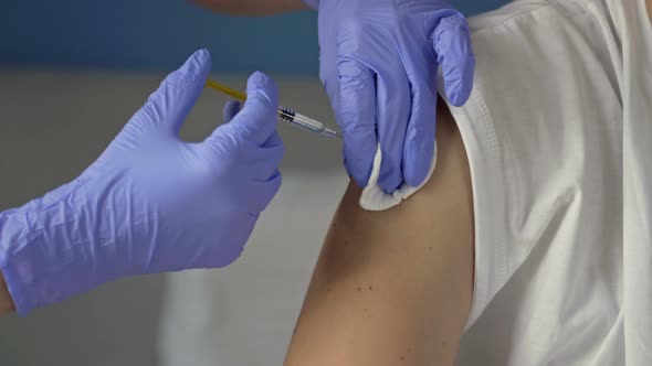 Hands of a Nurse Giving a Vaccine to a Patient