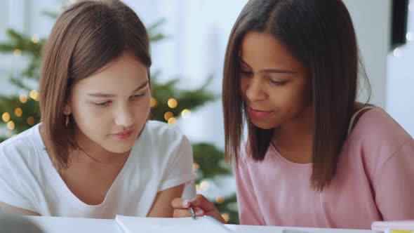 Concentrated sisters reading from notepad