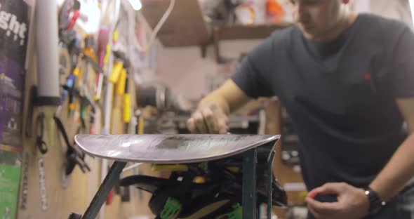 Ironing Hot Wax Onto Base Of Snowboard