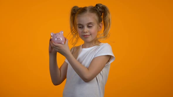 Adorable Girl Shaking Piggybank, Financial Literacy, Deposit for Future, Savings