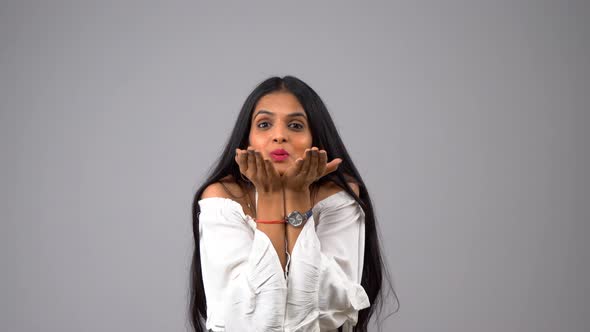 Happy Indian girl blowing flying kisses