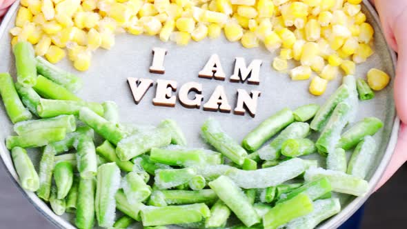 Female Hands Hold I AM VEGAN Text in Plate