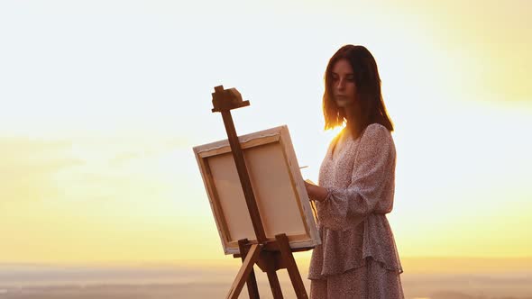 Painting Outside  Young Beautiful Woman Drawing a Painting at Sunset