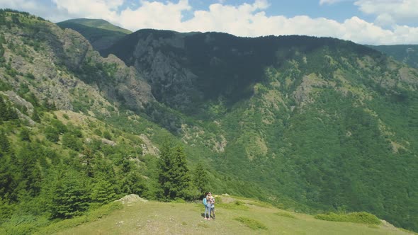 Lovely Couple Taking Selfie Photos at the Mountain Top with Deep Valley Below