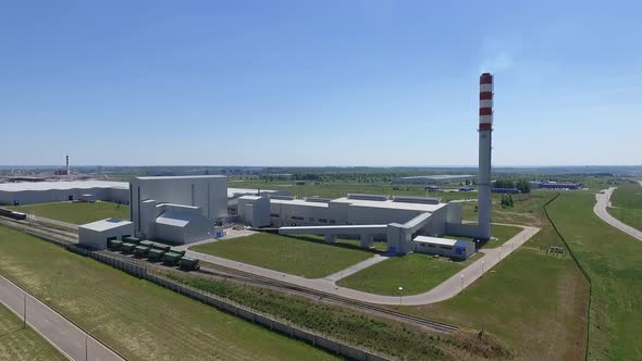 An Aerial View of a White Factory Building in Green Fields