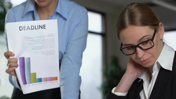 Angry Female Boss Shouting at Guilty Worker Holding Deadline Document, Stress