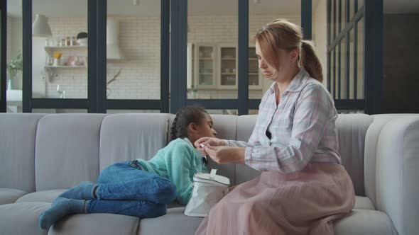 Mother Checking Temperature of Ill Child with Thermometer