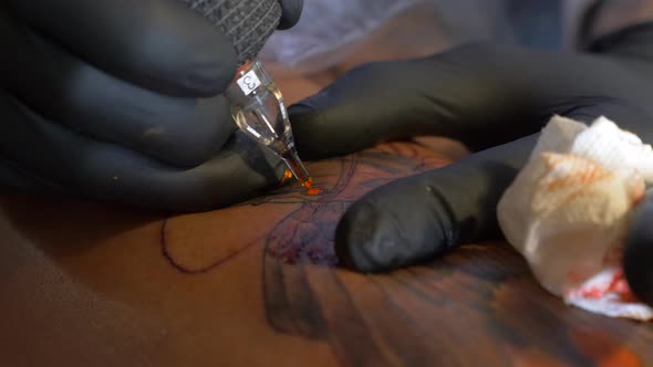 A Tattoo Artist Focus On Working With His Client To Perfectly Finish His Tattoo Art Design - Close u
