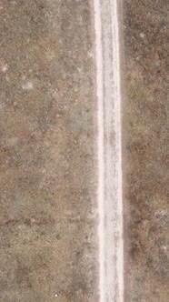 Vertical Video a Dirt Road Through an Empty Field
