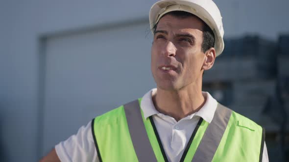 Handsome Middle Eastern Man in Hard Hat Looking Up Standing in Sunshine Outdoors