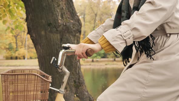 Woman Rides Bicycle Past Water Canal in Autumn Park