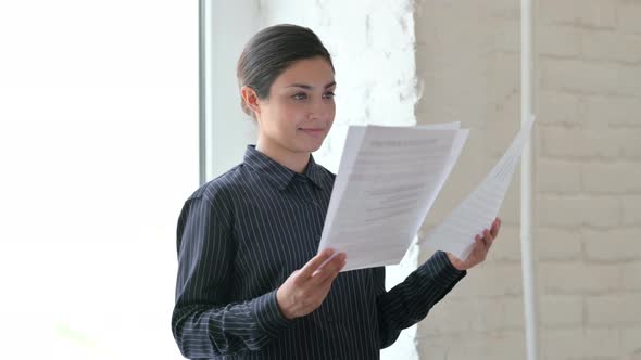 Indian Woman Standing and Reading Documents 