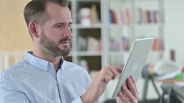 Portrait of Young Man Reacting to Loss on Tablet